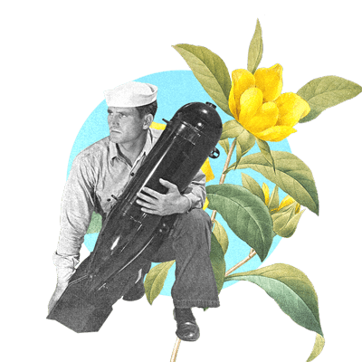 A navy sailor holding a torpedo with a yellow flower behind him